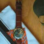 Close-up shot of a leather wristwatch on a stylish pouch, showcasing elegance and design.